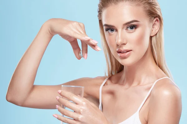 Ung Blond Flicka Visar Piller Handen Och Glas Vatten Blå — Stockfoto