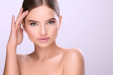 sabit saçlı ve çıplak mor arka plan üzerinde poz makyaj çekici genç kadın portresi
