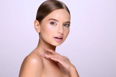 sabit saçlı ve çıplak mor arka plan üzerinde poz makyaj çekici genç kadın portresi