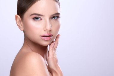 sabit saçlı ve çıplak mor arka plan üzerinde poz makyaj çekici genç kadın portresi