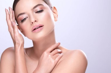 sabit saçlı ve çıplak mor arka plan üzerinde poz makyaj çekici genç kadın portresi