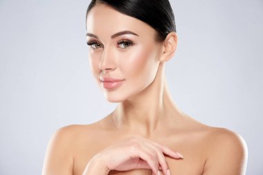 gri arka planda yüzünde çıplak makyaj ile genç kadın portresi