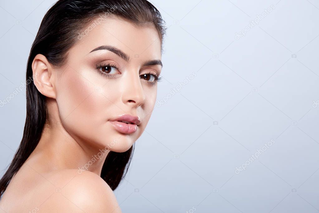 portrait of young beautiful woman with dark wet hair and nude make up