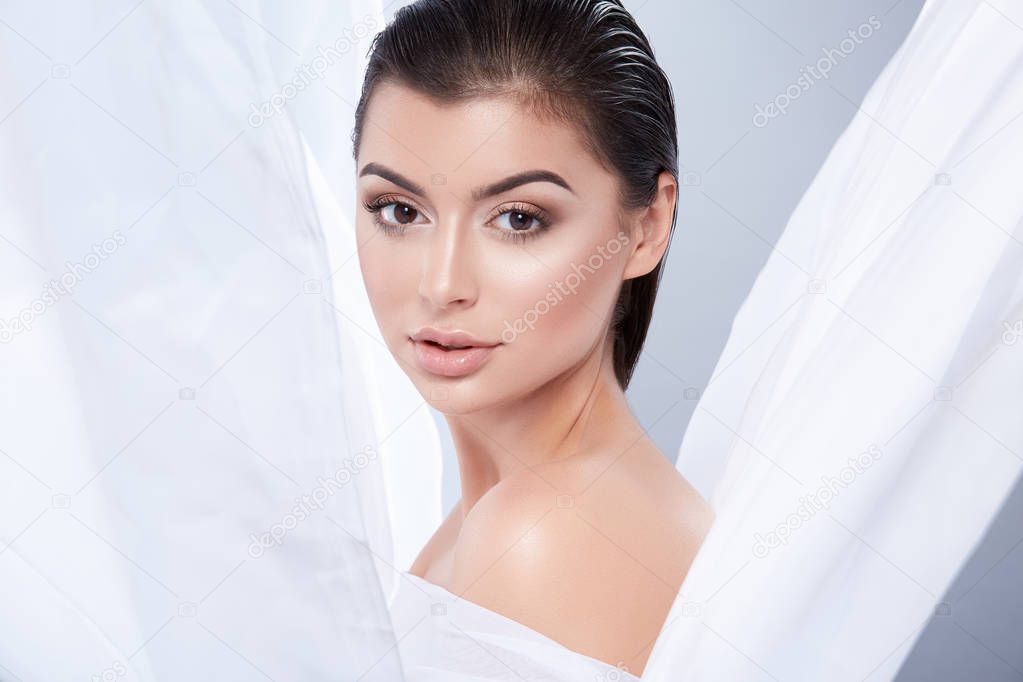 portrait of young beautiful woman with dark wet hair and nude make up