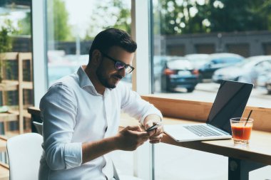 young handsome businessman with eyeglasses working in cafe