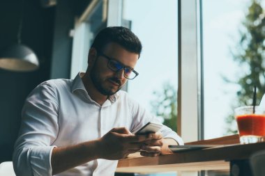 young handsome businessman with eyeglasses working in cafe