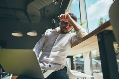 young handsome businessman with eyeglasses working in cafe