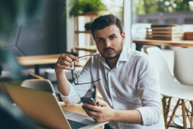 young handsome businessman with eyeglasses working in cafe