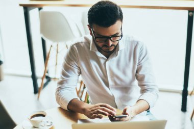 young handsome businessman with eyeglasses working in cafe
