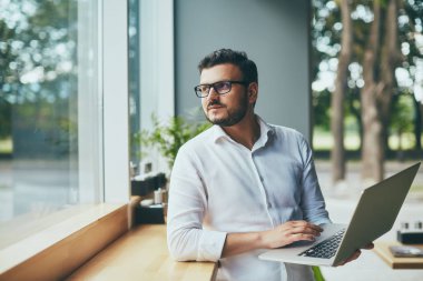 young handsome businessman with eyeglasses working in cafe