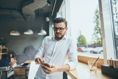 young handsome businessman with eyeglasses working in cafe