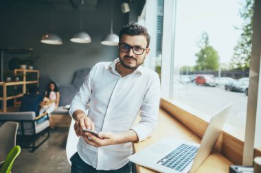 young handsome businessman with eyeglasses working in cafe