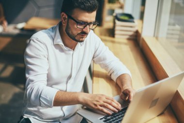 young handsome businessman with eyeglasses working in cafe
