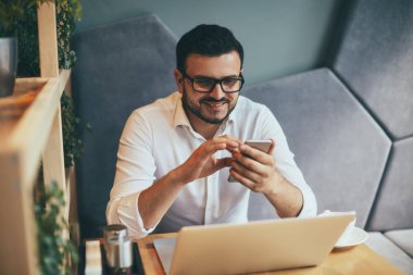 young handsome businessman with eyeglasses working in cafe