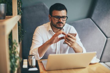 young handsome businessman with eyeglasses working in cafe