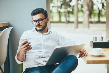 young handsome businessman with eyeglasses working in cafe