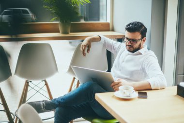 young handsome businessman working alone in cafe