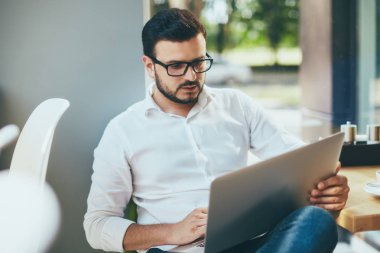 young handsome businessman working alone in cafe