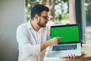 young handsome businessman showing laptop with blank screen in cafe