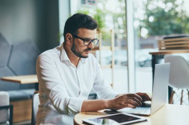 young handsome businessman working alone in cafe