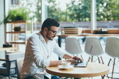 young handsome businessman working alone in cafe