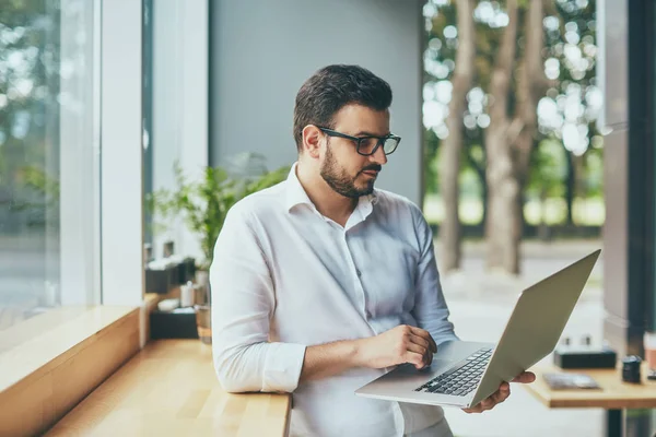 young handsome businessman with eyeglasses working in cafe
