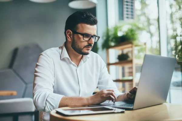 young handsome businessman working alone in cafe