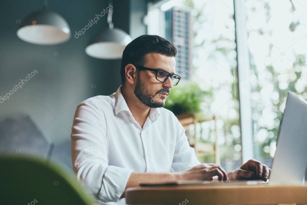 young handsome businessman working alone in cafe