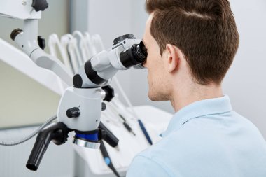 young male dentist in modern dental clinic