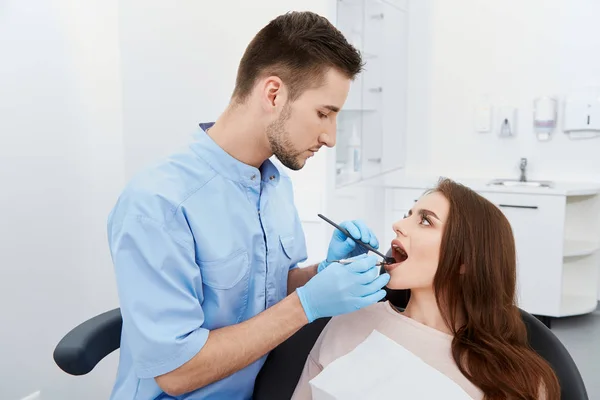歯科医院で若い女性患者の歯を硬化する歯科医 — ストック写真