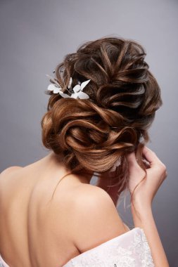 gri arka plan üzerinde poz kıvırcık saç modeli ile güzel genç kadının arka görünümü