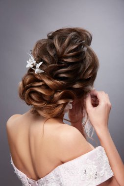 gri arka plan üzerinde poz kıvırcık saç modeli ile güzel genç kadının arka görünümü