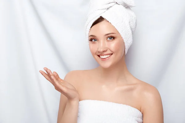 portrait of young woman with towel on head posing on light background
