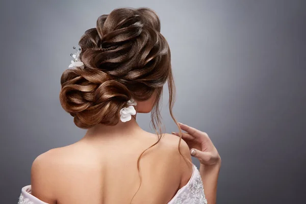 灰色の背景に背中から完璧な花嫁の髪型 — ストック写真