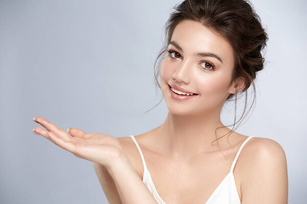 beautiful woman with perfect skin holding her arm for copyspace and smiling