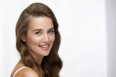 Güzel bayan kameraya bakıyor ve gülümsüyor, kopyalama alanı, esmer mankende inanılmaz sağlıklı saçlar