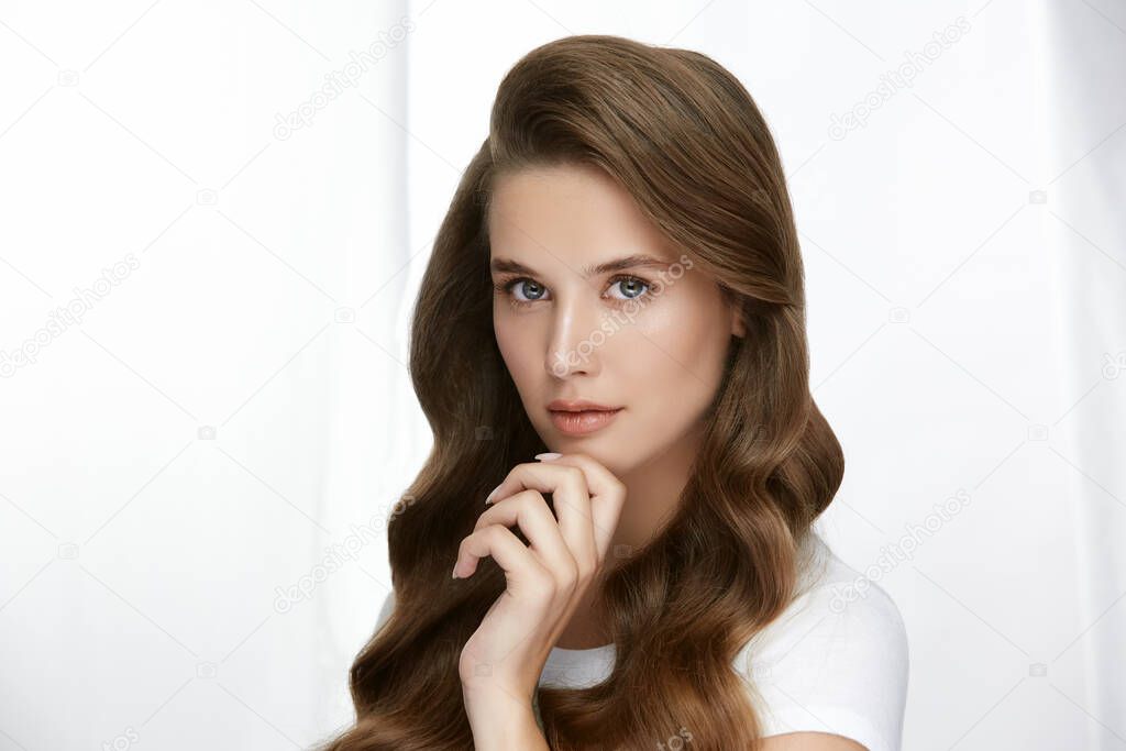 luxury woman portrait with amazing long hair, curly brunette with fresh clean skin looking to the camera isolated on white, beauty concept