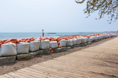 Plastik sel koruma kum torbaları geçici bir duvara yığılmış