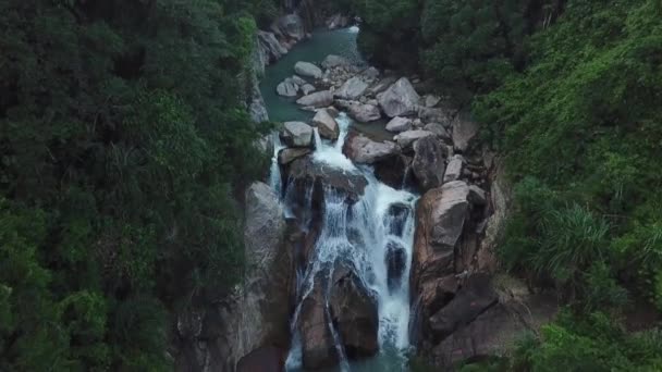 熱帯ヤシの森の野生の滝の上にドローンの上を飛ぶ。緑のジャングルと山の川の流れの美しい風景。自然の周りの水のカスケード。アジアの旅行コンセプト. — ストック動画