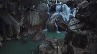 Tropik palmiye ormanlarındaki vahşi şelalenin üzerinde drone ile uçmak. Yeşil orman ve dağ nehri dere güzel manzara. Doğanın etrafında su çağlayan. Asya'da seyahat konsepti.