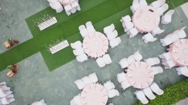 Drone düğün akşam yemeği dekorasyon üzerinde uçan, ya da evlilik yıldönümü, bahçede açık, sandalyeler ve masalar ayarlama Catering, havadan görünüm. Tropikal dekor tarzı atmosfer.