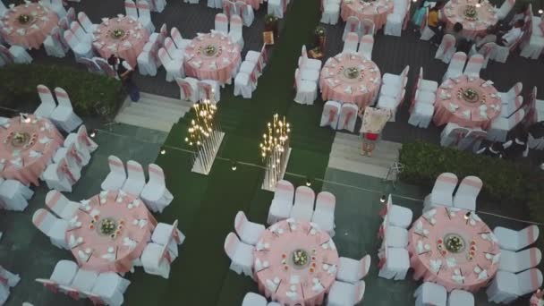 Drone düğün akşam yemeği dekorasyon üzerinde uçan, ya da evlilik yıldönümü, bahçede açık, sandalyeler ve masalar ayarlama Catering, havadan görünüm. Tropikal dekor tarzı atmosfer. — Stok video