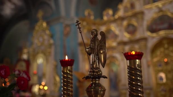 Inside the church, orthodox cathedral interior, religion concept. Ukrainian religion. Holy golden angel close-up. Slow-motion video, candle fire sticks. — Stock Video