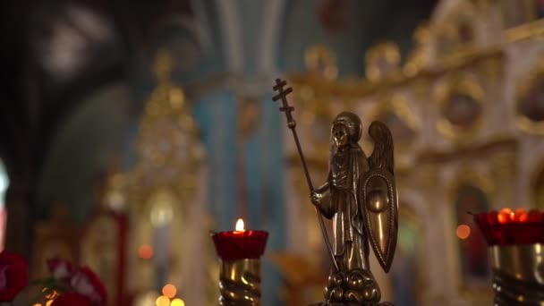 Inside the church, orthodox cathedral interior, religion concept. Ukrainian religion. Holy golden angel close-up. Slow-motion video, candle fire sticks. — Stock Video