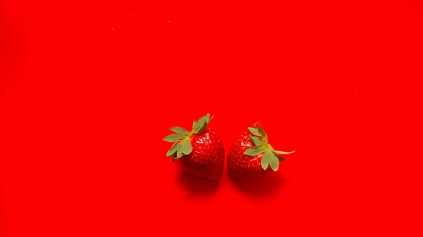 Close - up of the top view of fresh strawberries on a red background. Summer berry. Vitamins. The concept of proper nutrition.