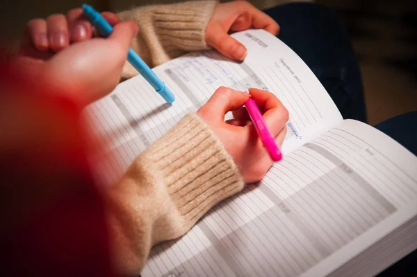 Not defteri ve kalem ile kadın el. İş planlaması, not defteri ve eller.