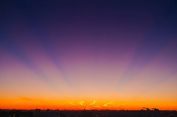 Nuvens laranja com trilhas de aeronaves fundo do céu e luz da cidade meia-noite à noite — Fotografia de Stock