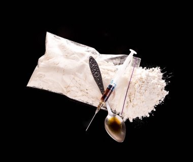 Uyuşturucu toz, ilaç şırınga ve siyah bir zemin üzerine kaşık yakın çekim ilaçtan.