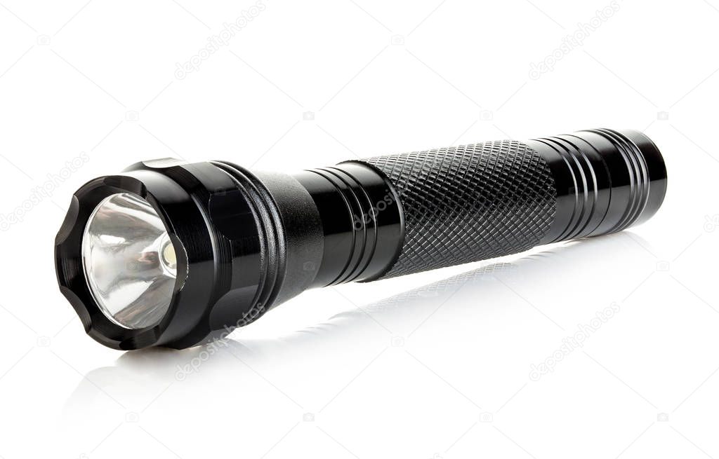 Black metallic flashlight close-up isolated on a white background.