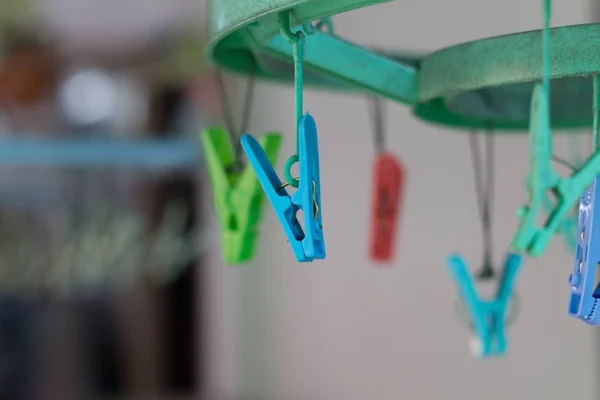Clothes pegs or clothespins hang on a cord. Plastic clothes pegs
